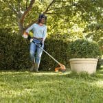 Frau bei Gartenpflege mit einem Rasentrimmer