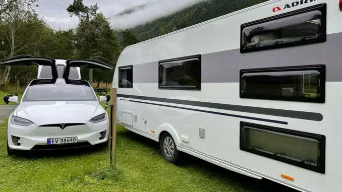 E-Auto neben Caravan auf Campingplatz